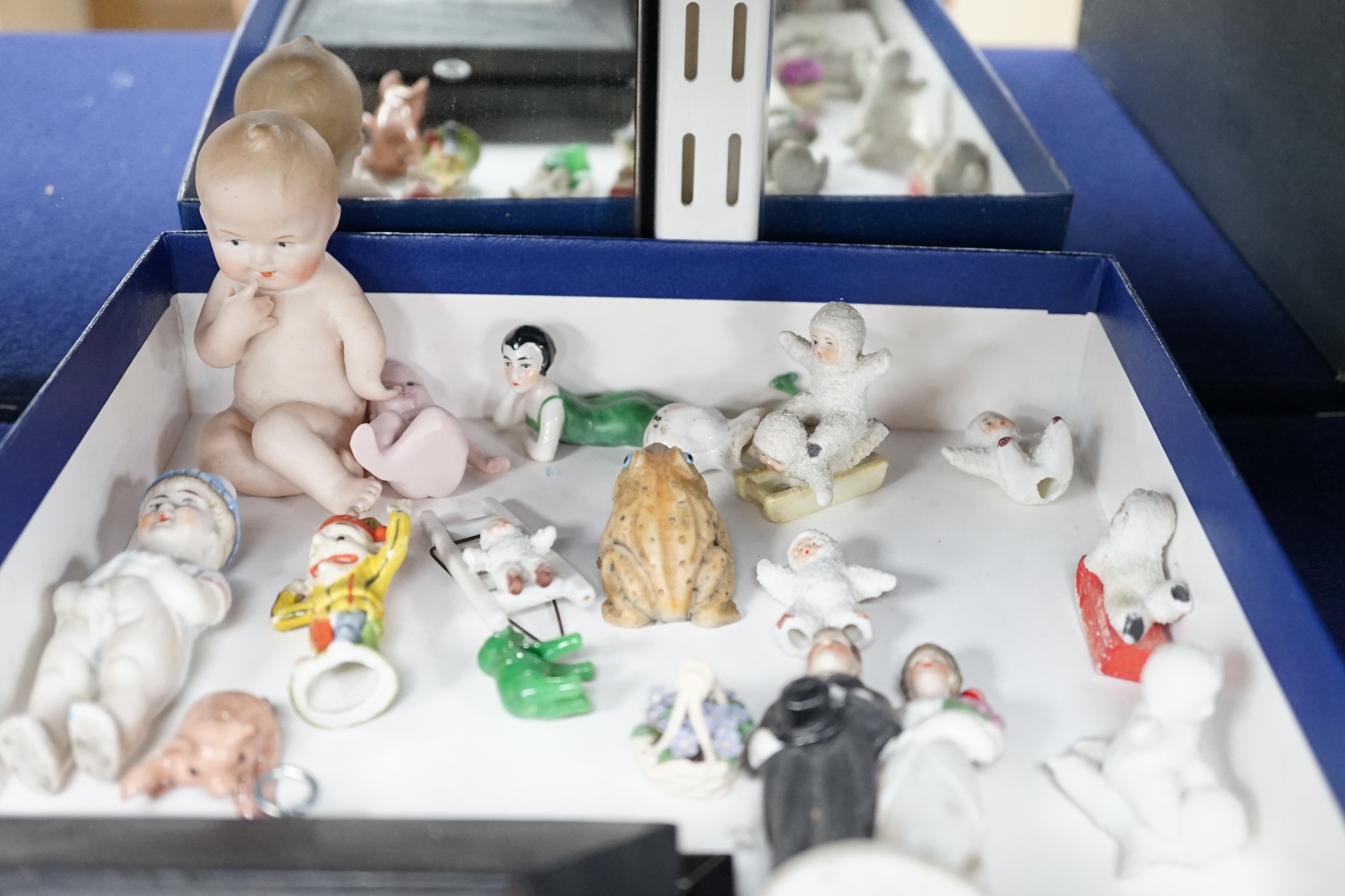 A collection of cabinet curiosities, including miniature cups, an ostrich egg, a Japanese marbled pottery teapot, a sand picture, snowmen cake decorations, etc. (2 trays). Condition - fair to good